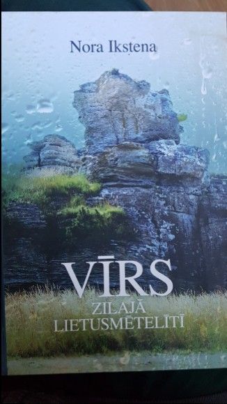 Vīrs zilajā lietusmētelītī